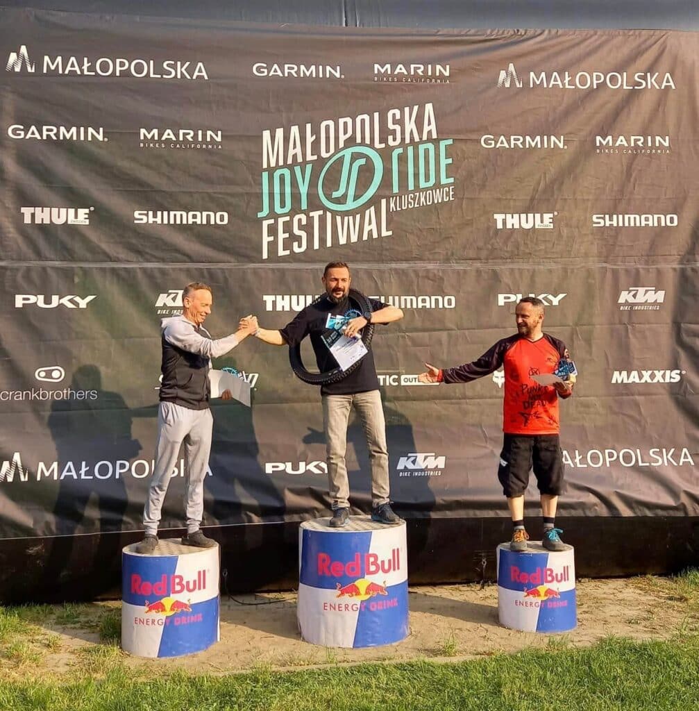 Arek Wróbel na najwyższym stopniu podium Joy Ride Festiwal w Kluszkowcach, z oponą rowerową na szyi